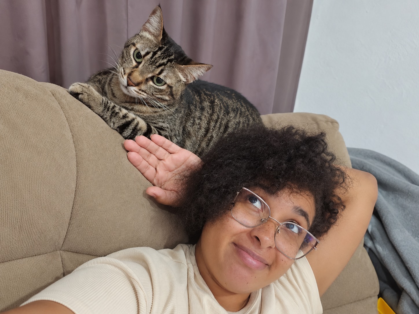 Patricia ao lado de um gato rajado em casa